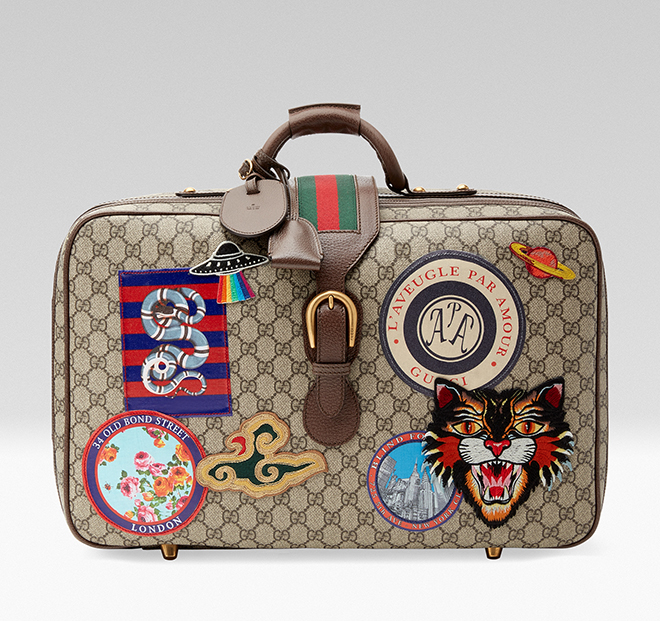 With the new rules of classic elegance, it might be time to re-look your travel accessories, starting with brave steps across the airport terminal toting the new Gucci Courrier GG Supreme suitcase. Travel continues to be a source of inspiration for Alessandro Michele. A collection of bags in the GG motif is enriched with a blend of contemporary embroideries-like the UFO-and vintage inspired details, including airmail trims. The appliqués are individually embroidered and then skillfully hand-applied to each piece by specialized artisans. This process ensures that no two items will be alike, giving each a one-of-a-kind appearance.