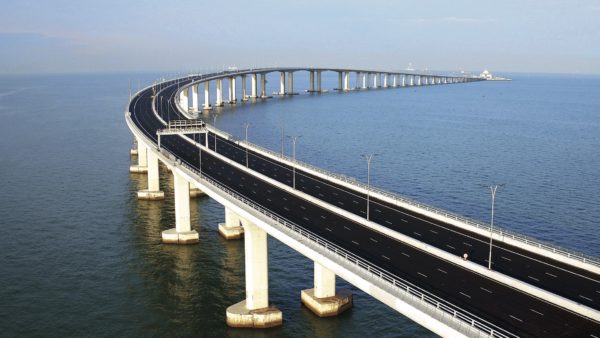 Potential benefits from the world’s largest bridge-and-tunnel sea crossing, opened late last year, are gradually becoming evident 