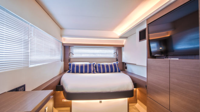 The master suite features a forward-facing bed towards the aft end of the starboard hull, separated from the engine compartment
